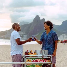 Cliente comprando milho de um vendedor na praia no Rio de Janeiro