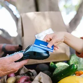 Pagamento com cartão na maquininha em uma feira